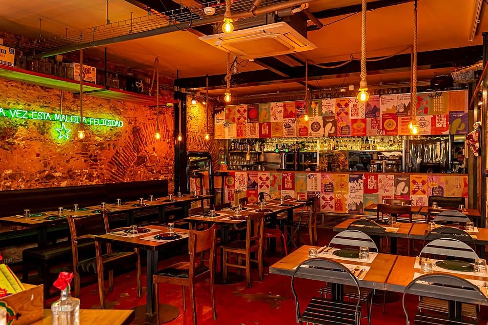 Las Ficheras dining room with painted mural wall and a spread of tacos